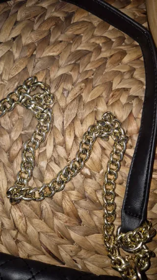 Bolso negro acolchado con cadena dorada