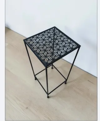 Mesa auxiliar negra con diseño geométrico