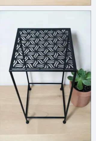 Mesa auxiliar negra con diseño geométrico