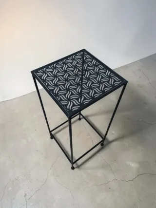 Mesa auxiliar negra con diseño geométrico