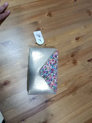 Bolso de mano dorado con pedrería multicolor