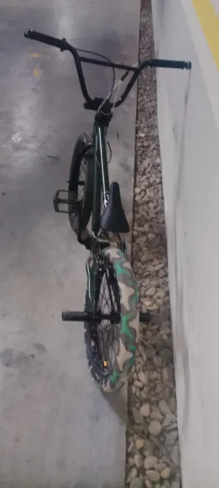 Bicicleta BMX verde con funda de rueda