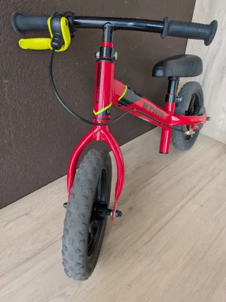 Bicicleta Btwin sin pedales roja con freno.