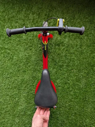 Bicicleta Btwin sin pedales roja con freno.