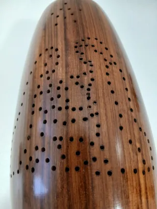 Jarrón de madera marrón con diseño perforado