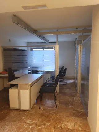 Mesa de oficina beige y negra con sillas.