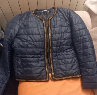 Chaqueta elegante azul con cadena dorada