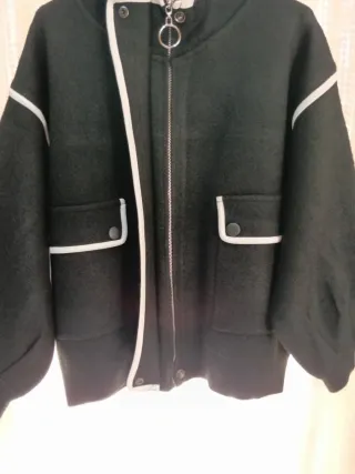 Chaqueta negra con ribete blanco. Muy buena calida