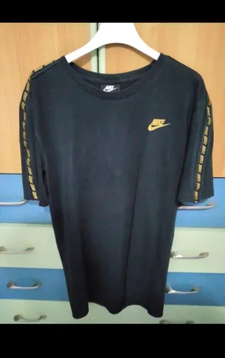 T-shirt Nike nera con logo dorato