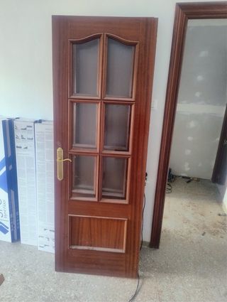 Puerta de madera oscura con manilla dorada