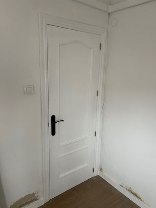 Puerta de madera oscura con manilla dorada