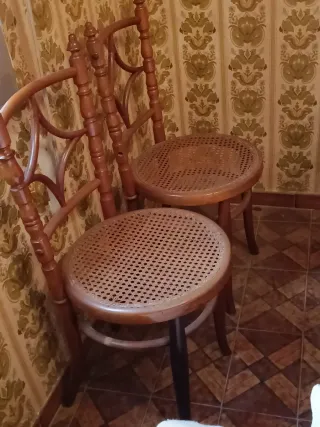 Cama antigua de madera con mesita y dos sillas