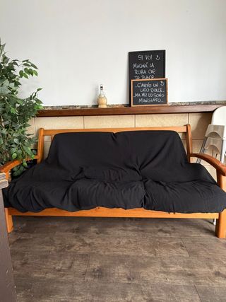 Sofá de madera con funda negra