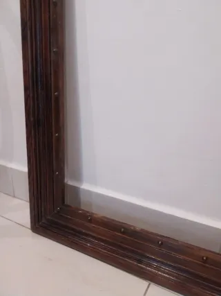 Marco de madera marrón con botones de bronce