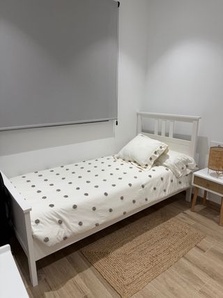 Cama individual blanca con somier y colchón.