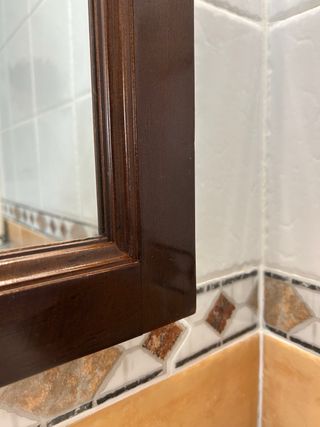 Espejo con marco de madera para baño con lámparas.