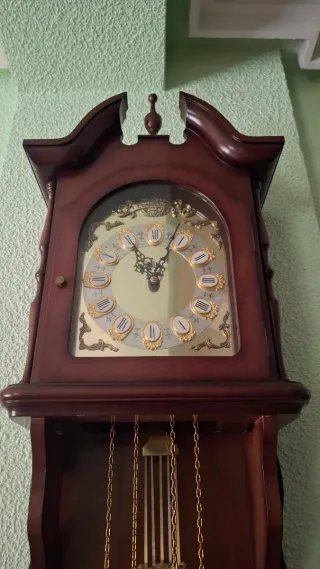 Reloj de pared de madera con péndulo.