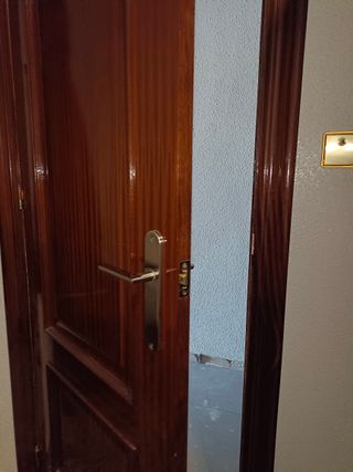 Puertas de interior en madera con marco y manilla.