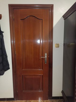 Puertas de interior en madera con marco y manilla.