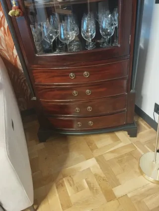 Vitrina de madera y sillón de piel