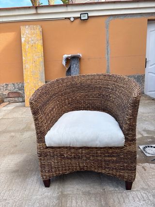 Sillón de mimbre con cojín blanco