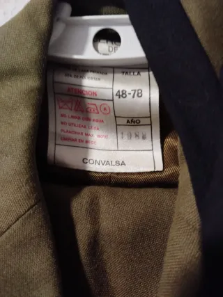 Traje verde con corbata negra y otra caqui.