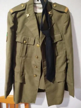 Traje verde con corbata negra y otra caqui.