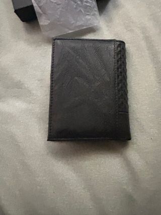 Cartera de piel negra con diseño texturizado