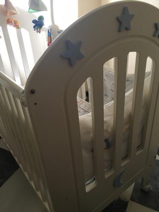 Cuna de bebé blanca con móvil