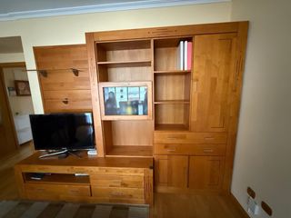 Mueble salón madera y cristal y mesas y sillas.