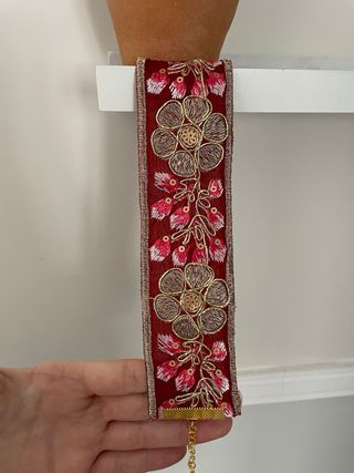 Gargantilla burdeos con flores doradas