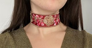 Gargantilla burdeos con flores doradas