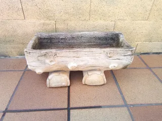 Jardinera de piedra con forma de tronco