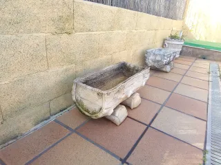 Jardinera de piedra con forma de tronco
