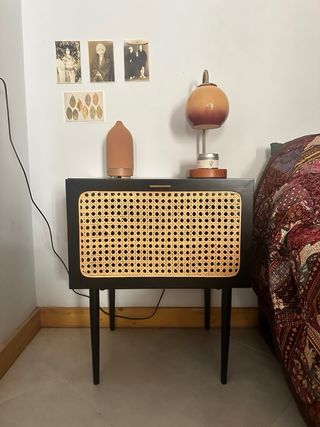 Mesita de noche negra con detalles en ratán