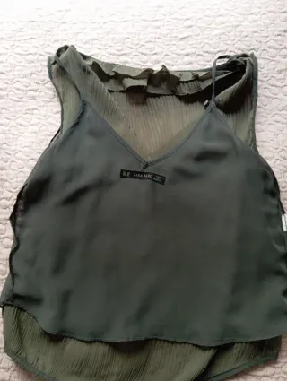 Blusa sin mangas verde con volantes.