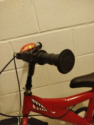 Bicicleta infantil roja con diseño de tiburón