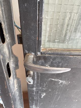 Puerta de forja con cristal y barrotes