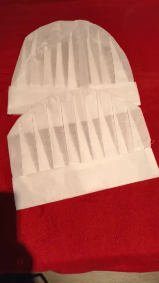 Delantales y gorros de cocinero blancos.