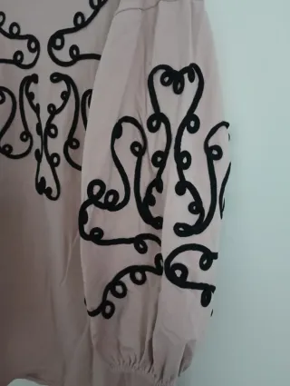 Sudadera rosa con adornos negros