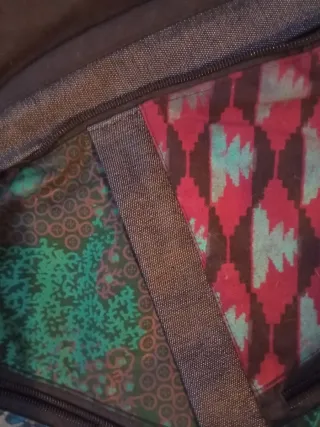 Mochila negra con parches multicolor.