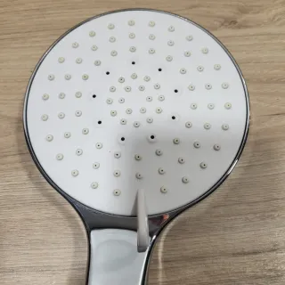 Cabezal de ducha plateado y blanco