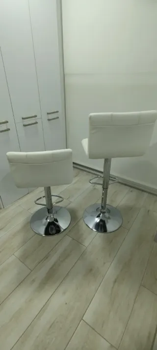 Taburetes altos blancos y plateados
