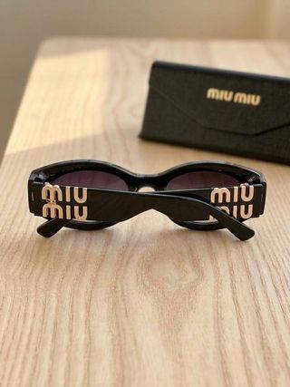 Gafas de sol Miu Miu negras y doradas