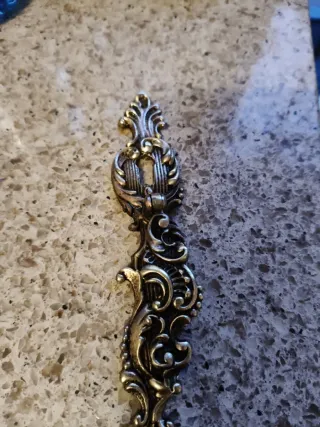 Tirador antiguo de metal dorado