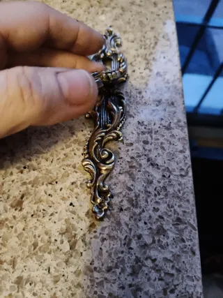 Tirador antiguo de metal dorado