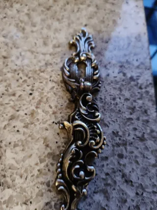 Tirador antiguo de metal dorado