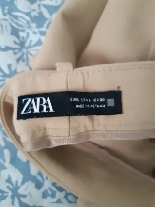 Pantalón beige con cinturón, con pinzas y bolsillo