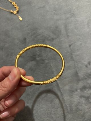 Pulsera dorada con diseño grabado