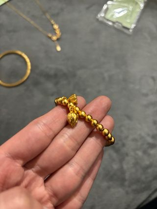 Pulsera dorada con dijes de flor